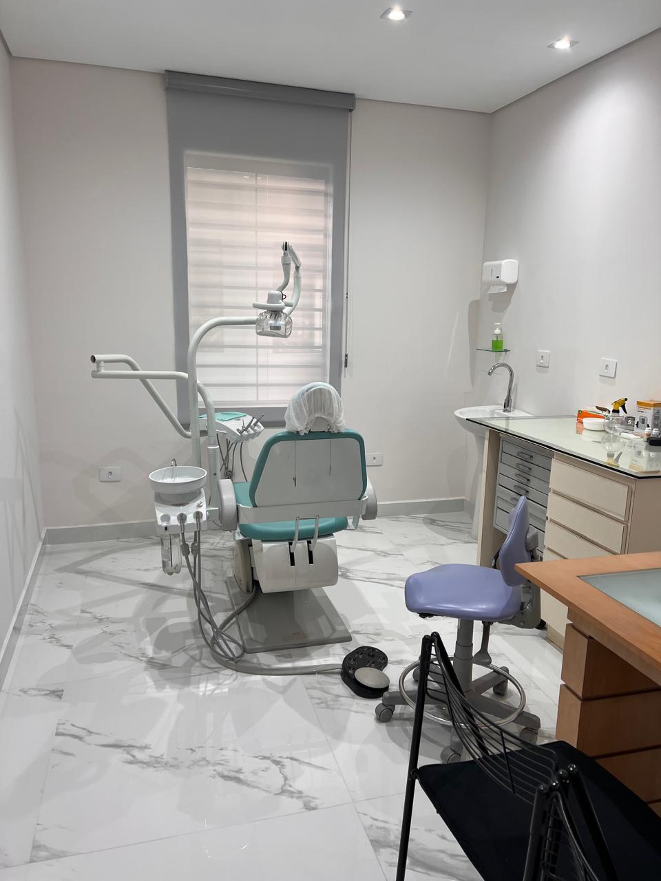 Consultório com cadeira odontológica e bancada de trabalho